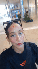 Woman records selfie video near mural in Pampatar, Venezuela