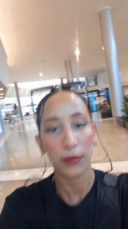 Woman records selfie video near mural in Pampatar, Venezuela