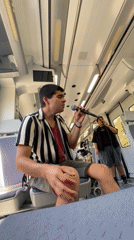 Young man sings with microphone on train in Barcelona area