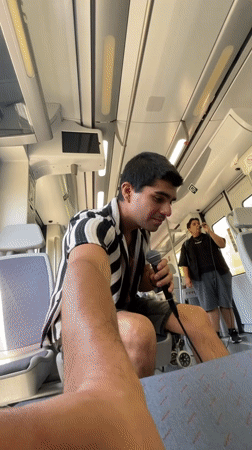 Young man sings with microphone on train in Barcelona area