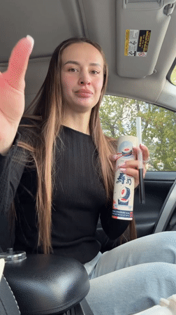 Woman displays Sushi Party container contents in Kyiv car