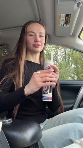 Woman displays Sushi Party container contents in Kyiv car