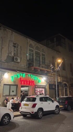 Evening diners gather at illuminated HaKtzav restaurant in Tel Aviv