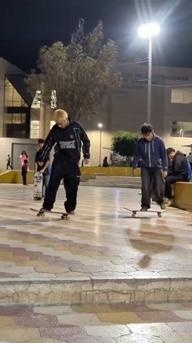 Young skateboarders practice tricks at Tacna plaza during late night
