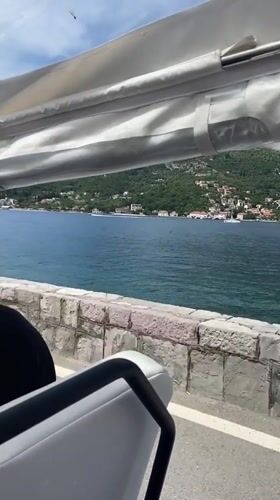 Tourists ride open-air transport along Montenegro coastal road