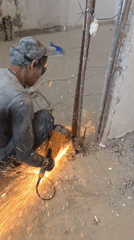 Construction worker cuts metal with grinder in Bat Yam