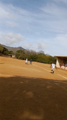Amateur baseball game documented on dirt field