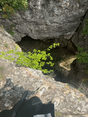 Two people explore natural sinkhole near cliffs in Ruse