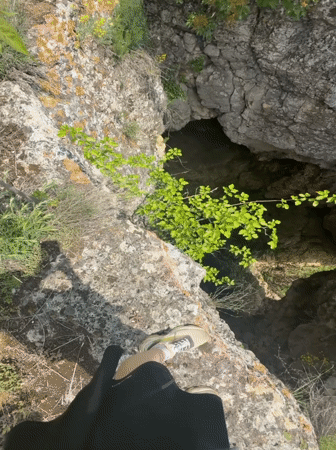 Two people explore natural sinkhole near cliffs in Ruse