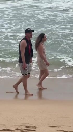 Couple enjoys morning beach walk in Thalaramba, Sri Lanka