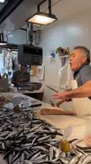 Fishmonger processes catch at Málaga market Saturday morning