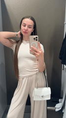 Woman takes fitting room selfies in beige outfit, Kyiv