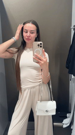 Woman takes fitting room selfies in beige outfit, Kyiv
