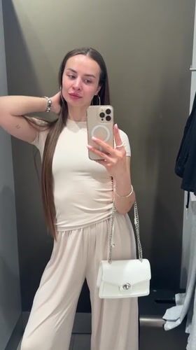 Woman takes fitting room selfies in beige outfit, Kyiv