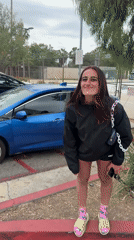 Woman deals with flat tire in LA parking lot