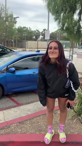 Woman deals with flat tire in LA parking lot