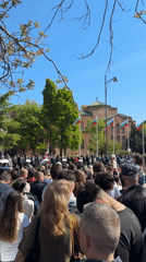 Crowd gathers near domed building with Bulgarian flags in Sofia