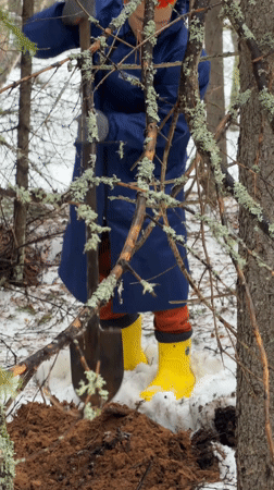 Person digging in snowy Russian forest near Chaikovsky