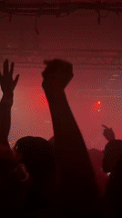 Concert crowd enjoys live music under red lights in London