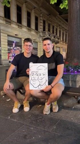Street artist draws caricatures for customers in Belgrade evening