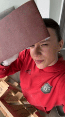 Person sands wood on Sofia balcony wearing Manchester United hoodie