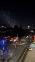 Fireworks and colored lights over Niagara Falls on a busy night