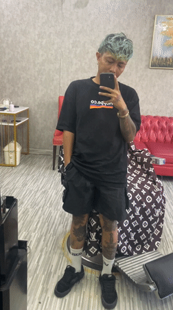 Tattooed man takes late-night selfie in upscale Kuta barbershop