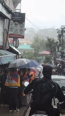 Rainy streets and school uniforms on a busy morning