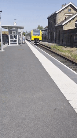 Train arrives at Evergem station on a sunny morning