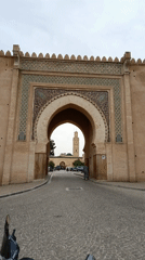 Tourists and locals document historic Meknes landmarks and cityscape