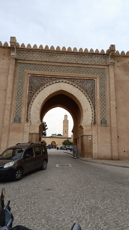 Tourists and locals document historic Meknes landmarks and cityscape