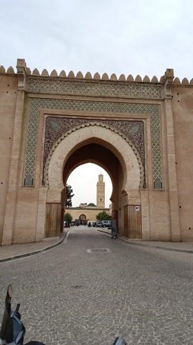 Tourists and locals document historic Meknes landmarks and cityscape