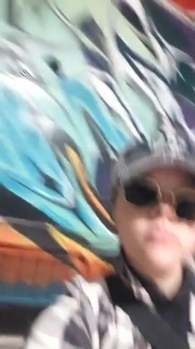 Person poses before colorful mural in Penticton