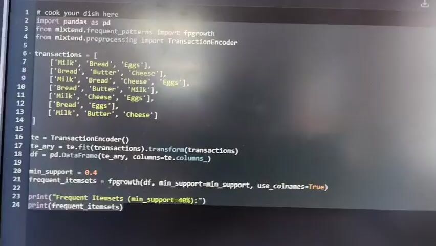 The video shows a close-up view of a computer screen displaying Python code. The code is related to data analysis and uses libraries like pandas and mlxtend. The screen shows a list of transactions, likely representing customer purchases, and then proceeds to encode these transactions and find frequent itemsets using the FP-growth algorithm. The minimum support is set to 0.4. The output of the frequent itemsets is then printed to the console. The environment appears to be an indoor setting, likely an office or home, with the computer screen being the primary focus. There are no people visible in the video.