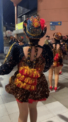 Nighttime street festival with costumed dancers and live performers