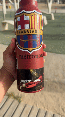 Man displays customized Barcelona FC water bottle with skateboard stickers