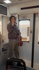 Street musician performs with violin on Spanish train