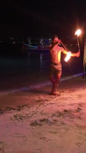 Fire dancer performs nighttime show at Choeng Mon beach Thailand