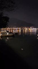 Calm bay waters reflect city lights in Fethiye, Turkey