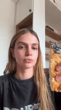 Woman displays decorated cake slice near documented elevator location