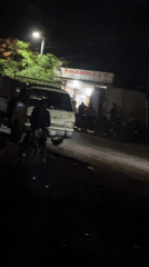 Nighttime street gathering recorded near pharmacy in Bukuru, Nigeria