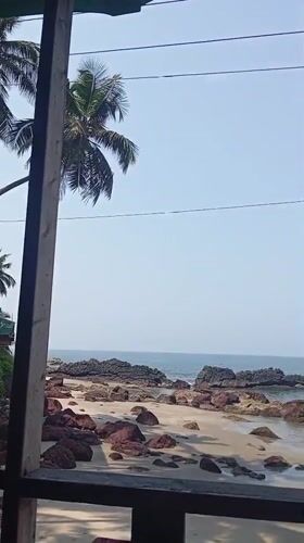 Man observed on balcony overlooking Querim beach early morning