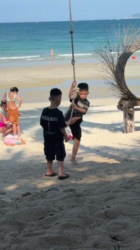 Tropical beach day with rope swings and photo props