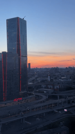 Mytishchi skyline at dusk, red-lit skyscraper in frame