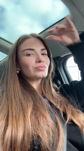 Woman driving Mercedes through Moscow streets smiles at camera