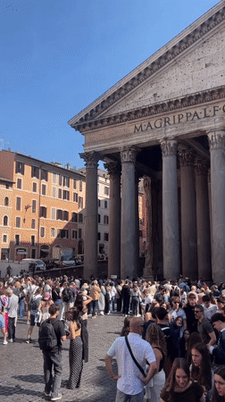 Tourist documents Rome's historic landmarks during sunny afternoon walk