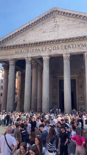 Tourist documents Rome's historic landmarks during sunny afternoon walk