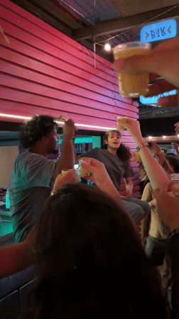 Man with megaphone rallies crowd from São Paulo bar counter
