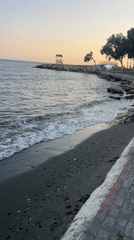 Dusk along Agios Tychona's dark-sand beachfront promenade, Cyprus
