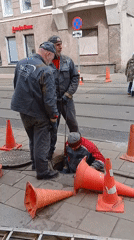 Utility workers perform street manhole maintenance in Moscow